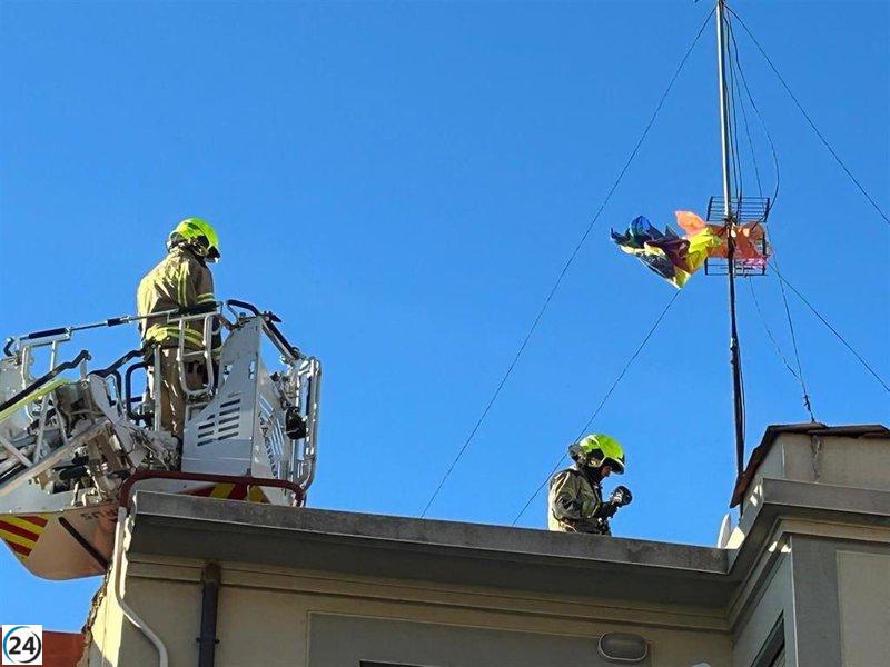 Bomberos retiran un globo de papel de la antena de un edificio en Logroño.